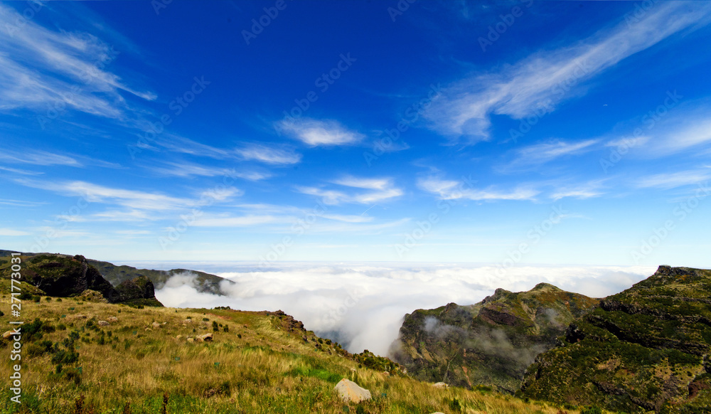 Wide angle shot of Mountain peaks against blue sky with white clouds on a beautiful summer day. Near Pico de Areeiro (Arieiro), Central Madeira, Portugal, Europ