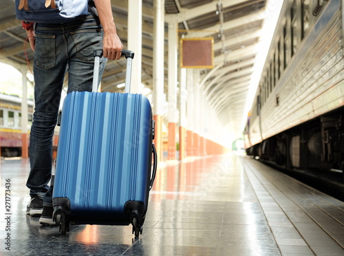 Traveler with a blue suitcase is waiting for the train. © sarawutnirothon