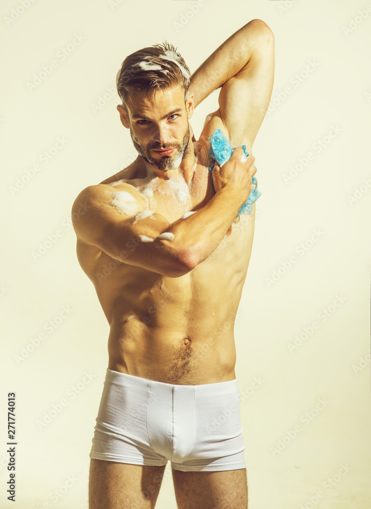 Young man taking bathroom. Bodycare, skincare, cleaning concept. Sexy man with naked body washing with sponge. Muscular man in shower. Morning hygiene. bearded man washing in shower Stock Photo