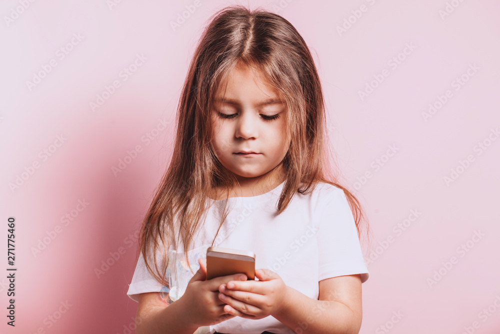 Happy little girl talking on telephone on pink background Happy little girl talking on telephone on pink background