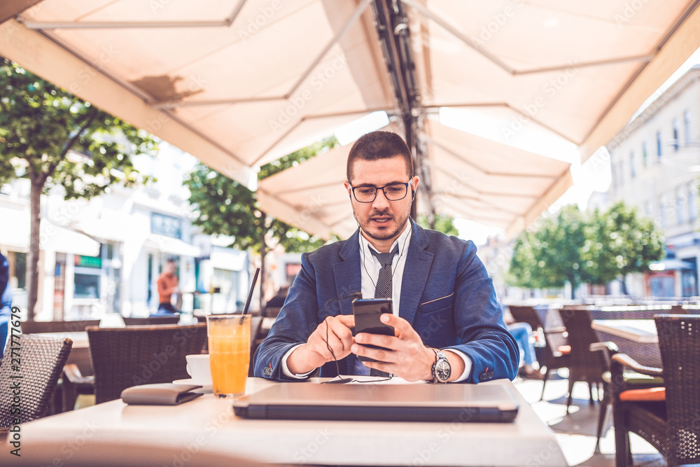 Handsome man in suit relaxing at cafe and speaking on smart phone Handsome man in suit relaxing at cafe and speaking on smart phone