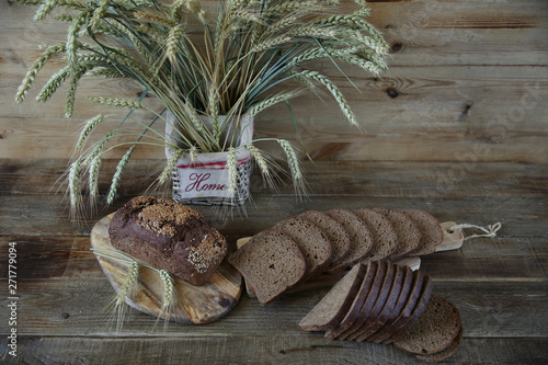 rye bread and rye ears in a basket with the inscription HOME on a wooden rustic background with copy space for text