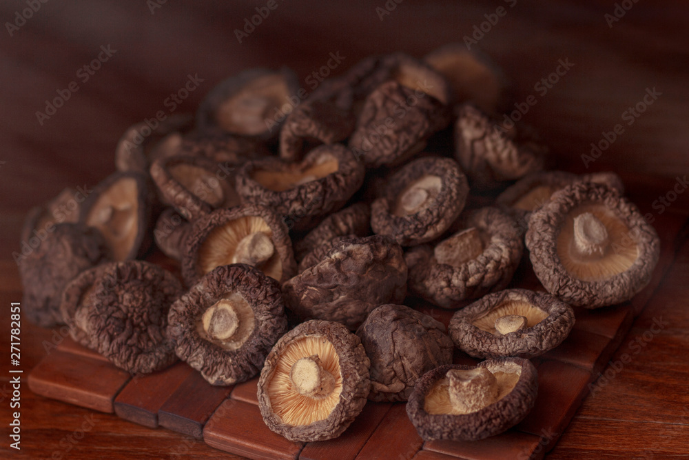 dried mushrooms lie on a wooden dark colored surface and blackboard dried mushrooms lie on a wooden dark colored surface and blackboard