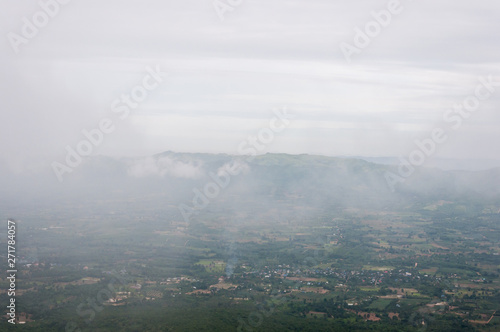 The light fog is floating over the countryside village.