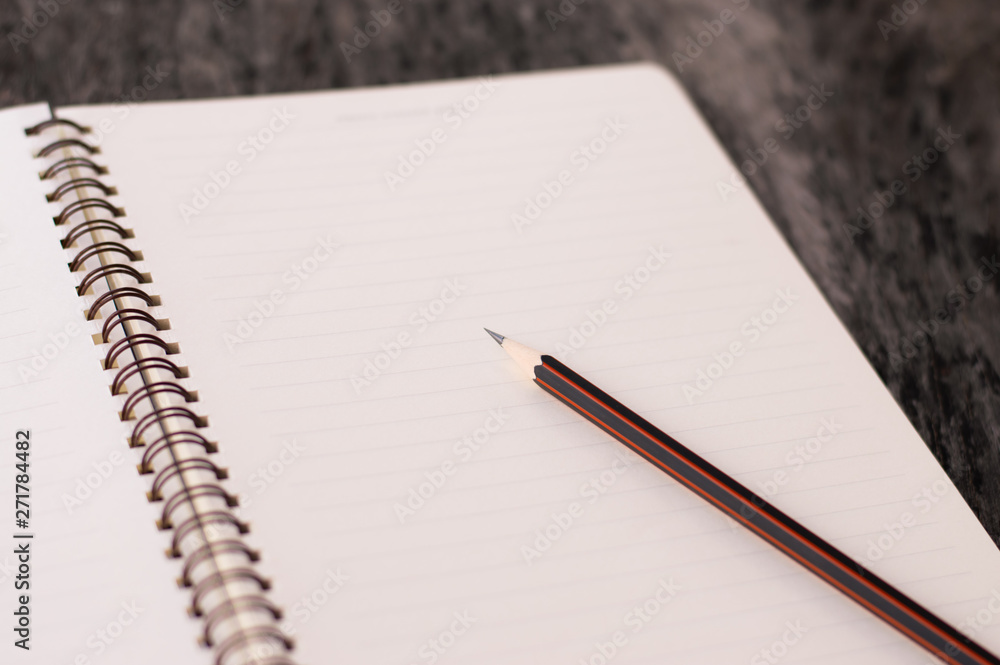 Notepad with pencil on wooden table background. Notepad with pencil on wooden table background.