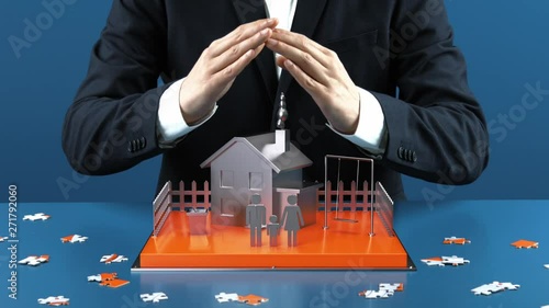 Mann in Anzug vor Schreibtisch hält seine schützende Hand über ein kleines Haus und seine Familie in 3D (ID: 271792060)