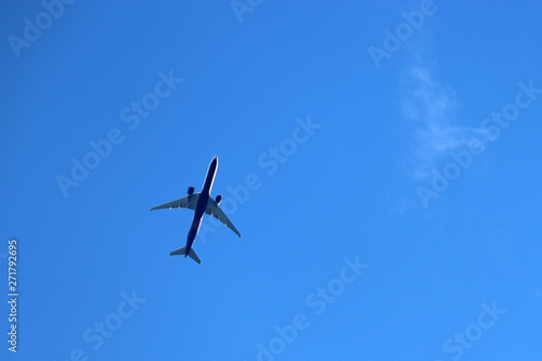 Airplane in the clear blue sky. Commercial jet plane in a flight close up, bottom view