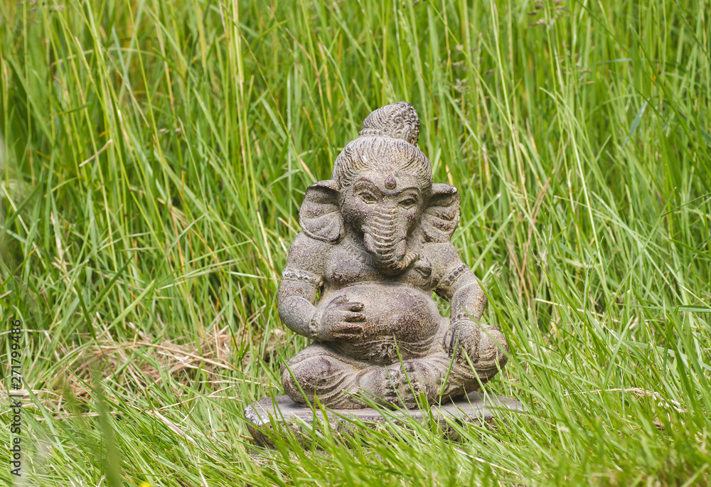 Ganesh stone statue in the green grass