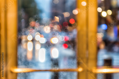 Grand central terminal entrance, traffic cars bokeh, from Lexington Avenue in New York City NYC, rainy day or evening, looking outside through door window blurred abstract background
