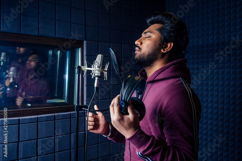 professional singing indian men headphones sound modern studio violet background recording song.