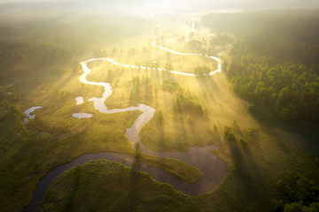 Misty morning river in sunlight. River landscape aerial view. Riverside view from above. Summer nature in sun rays. Drone view on  sunny nature. Scenery river top view.