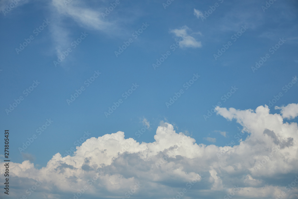 White clouds on bright blue sky with copy space