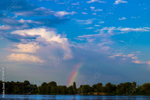 Rainbow under a storm cloud over the lake