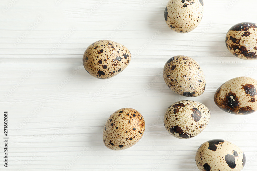 Obraz premium Flat lay composition with quail eggs on white wooden background, space for text and closeup