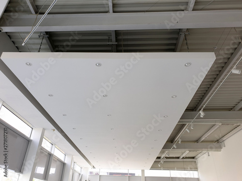 White suspended ceiling with LED spotlights. Showroom