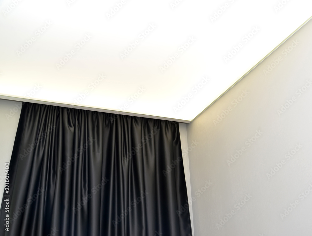 Fragment of the lit stretch ceiling and black silk portiere Fragment of the lit stretch ceiling and black silk portiere
