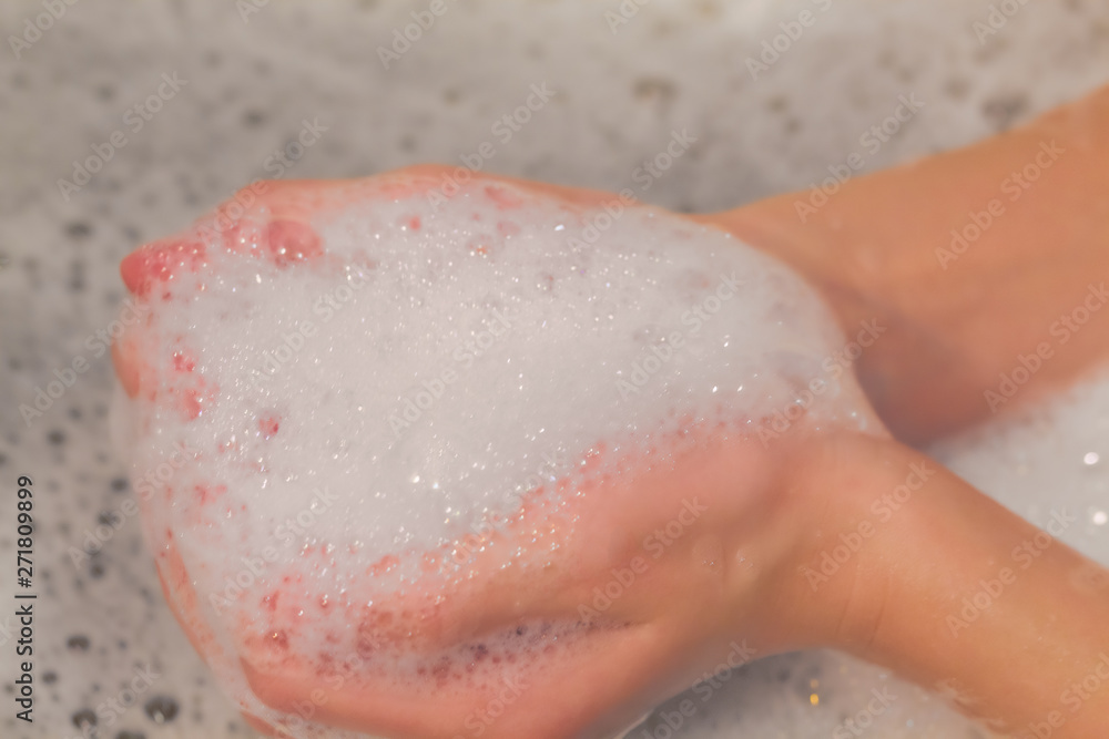 Fototapeta premium Soap foam on hands in bath. concept of purity