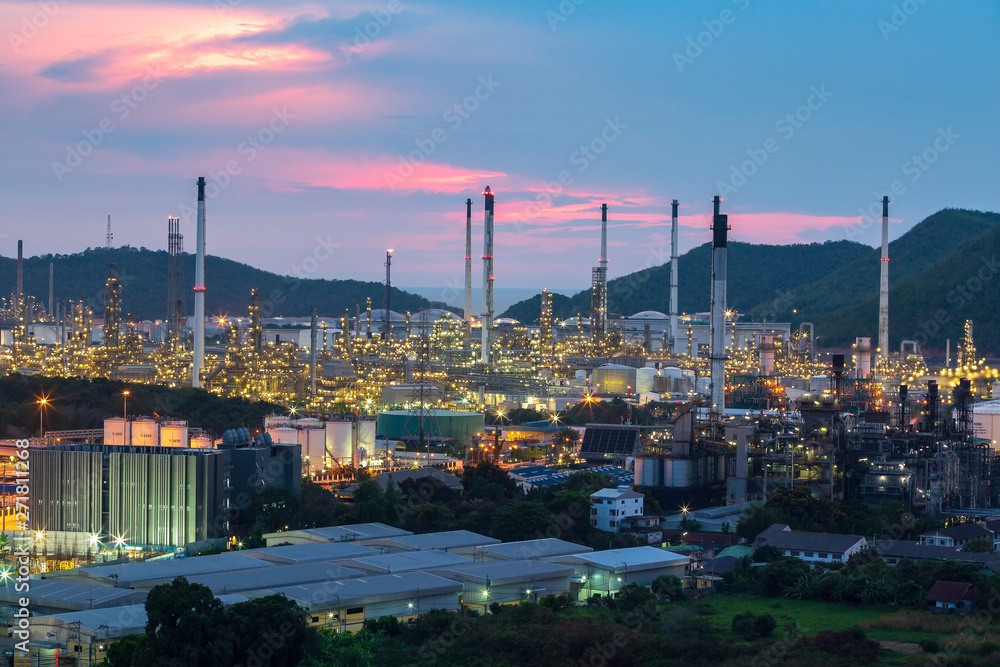 Obraz premium Petrochemical oil refinery plant with equipment chemical tank and high chimney smoke in night light at industry area