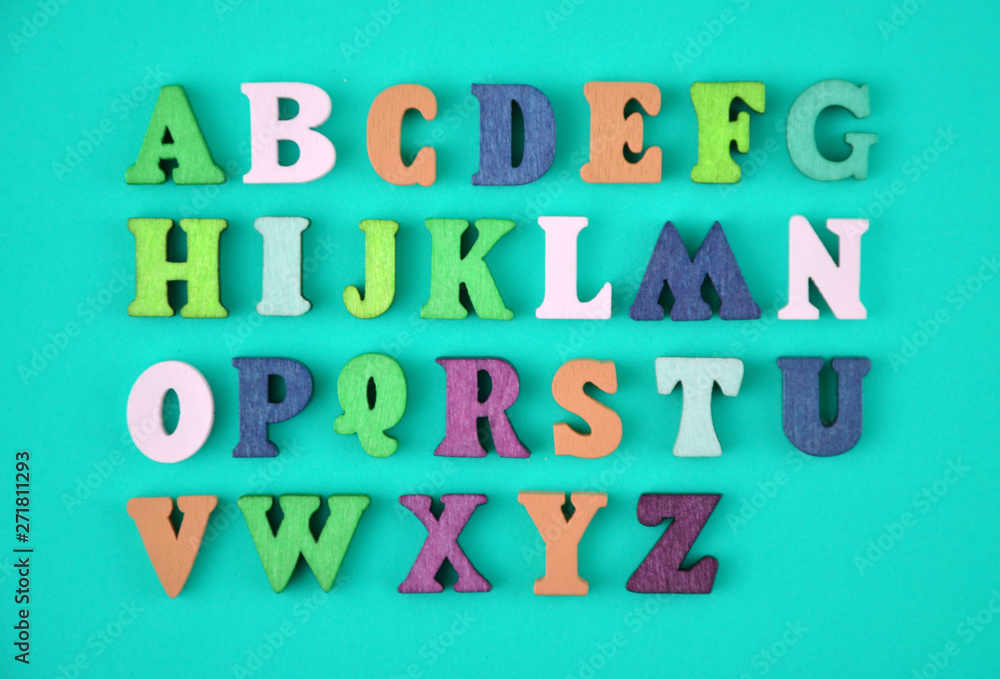 English alphabet made of multi-colored wooden letters on blue background