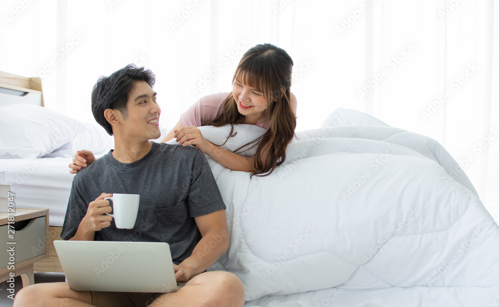 An Asian couple is taking rest in the bedroom