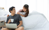 An Asian couple is taking rest in the bedroom