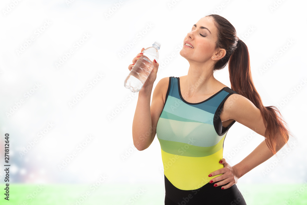 Beautiful young sports lady drinking water and posing isolated over white background. Beautiful young sports lady drinking water and posing isolated over white background.