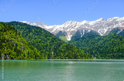 View of lake Ritsa (Riza) in Abkhazia in the spring, in the background snow-capped mountains 