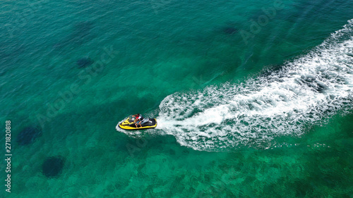 Aerial drone top view photo of jet ski cruising in high speed in emerald exotic tropical bay © aerial-drone