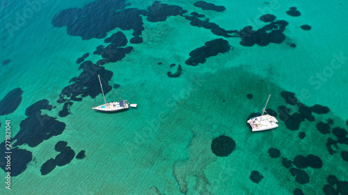 Aerial drone top view photo of sail boat docked in tropical exotic bay with emerald calm sea