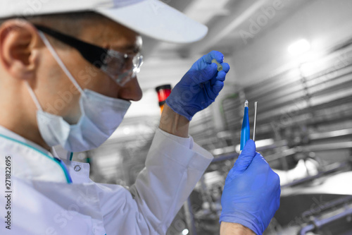 man in a white robe and a cap make an inspection of dairy products