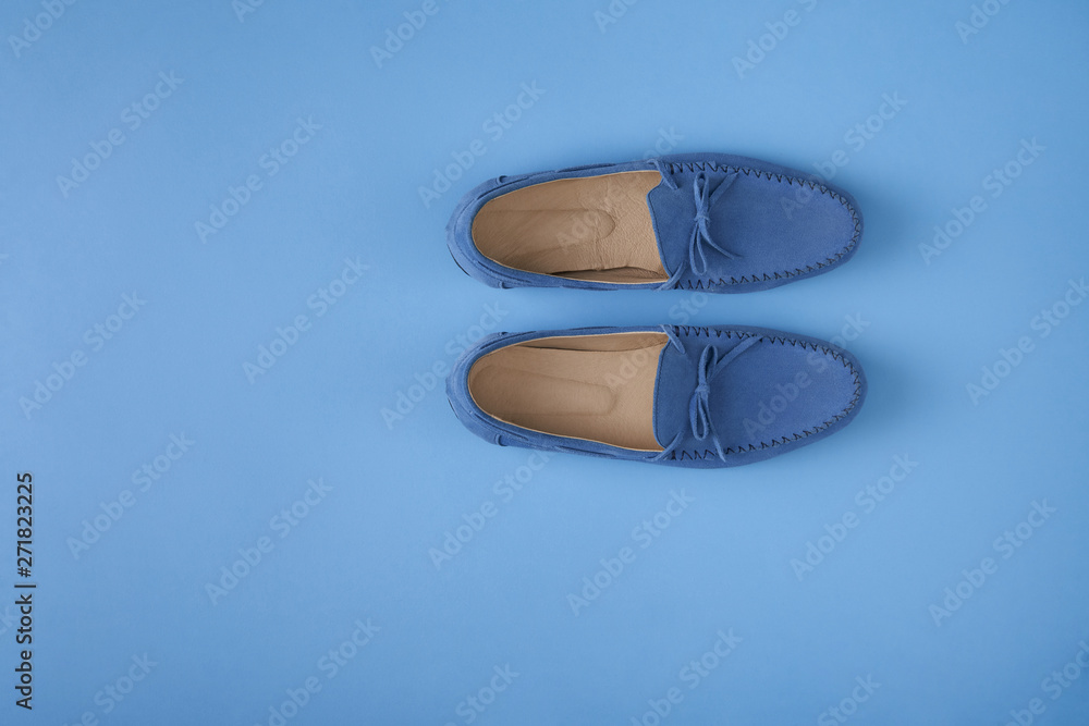 Fototapeta premium Blue suede man's mocassin shoes over blue background