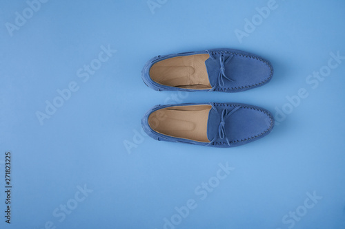 Blue suede man's mocassin shoes over blue background