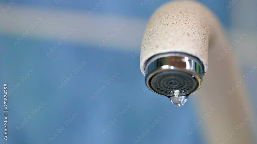 Dripping water from a water tap close-up. Faulty water faucet. Water leakage problem. Worldwide problem of safety of drinking fresh water. Concepts safety water resources. Dripping water from a water tap close-up. Faulty water faucet. Water leakage problem. Worldwide problem of safety of drinking fresh water. Concepts safety water resources.