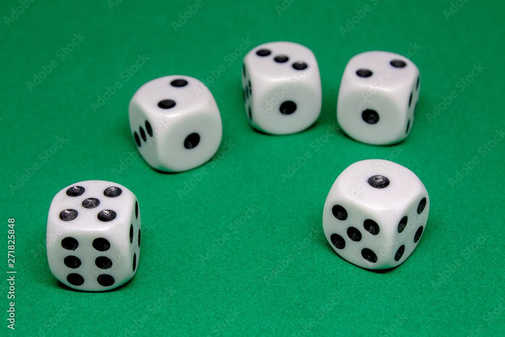 Five white dice scattered on the green game table close-up Five white dice scattered on the green game table close-up