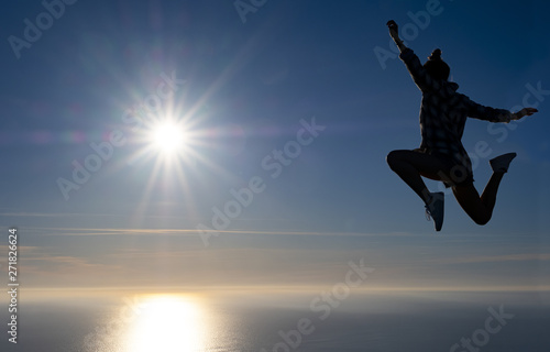 Free girl celebrated success with the sea and the sun in the background