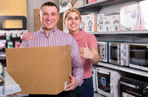 Couple  with packed purchases in  household appliances section © JackF