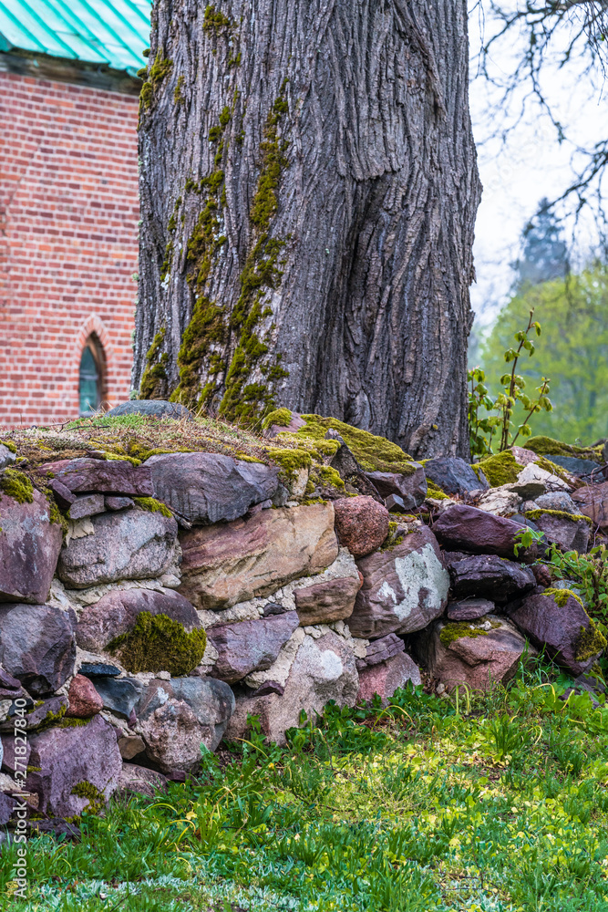 Fototapeta premium various brown and mottled boulders close up, stacked, some of them overgrown with moss and grass