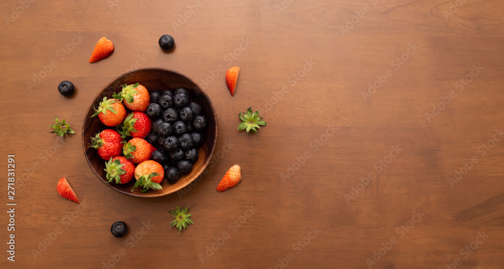 Fresh strawberry and blueberry in wood bowl, Copy space on the right