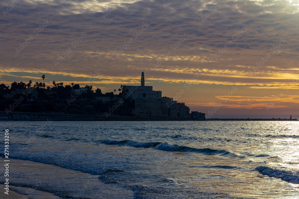 Old Jaffa in silhouette from a nearby beach