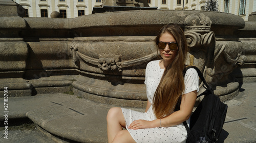 Photography Young girl student posing by the fountain on a sunny day in Prague Castle in Pra