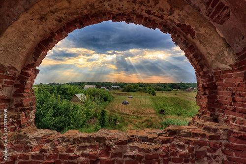 Behang View through the window of an abandoned church in Russia at the village at suns