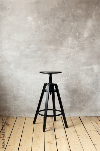 Bar stool on the gray background of the wall. Free space for text.