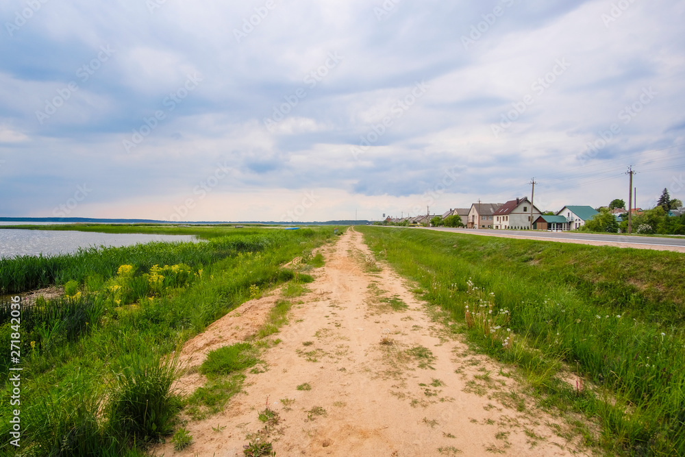 Braslavl, Belarus - May, 26, 2019: image of country road along rural houses and lakes in Braslavl, Belarus
