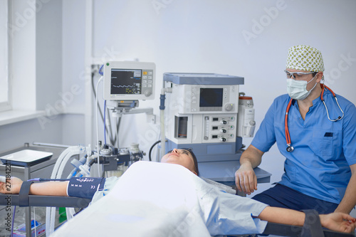 Several doctors surrounding patient on operation table during t