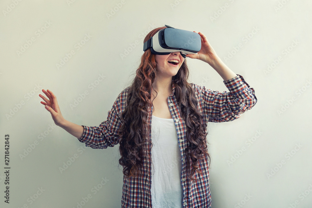 Smile young woman wearing using virtual reality VR glasses helmet headset on white background. Smartphone using with virtual reality goggles. Technology, simulation, hi-tech, videogame concept Smile young woman wearing using virtual reality VR glasses helmet headset on white background. Smartphone using with virtual reality goggles. Technology, simulation, hi-tech, videogame concept