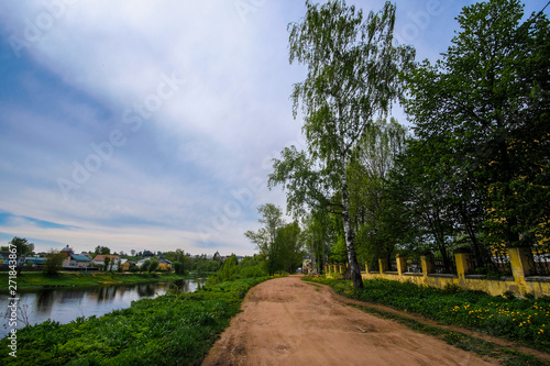 the image in the foreground of a country road and in the distance the visible city of Torzhok, Russia