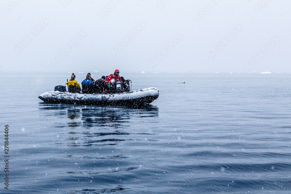 Snowfall over the Zodiac boat with frozen polar divers near Almirante Brown, Antarctic peninsula Snowfall over the Zodiac boat with frozen polar divers near Almirante Brown, Antarctic peninsula