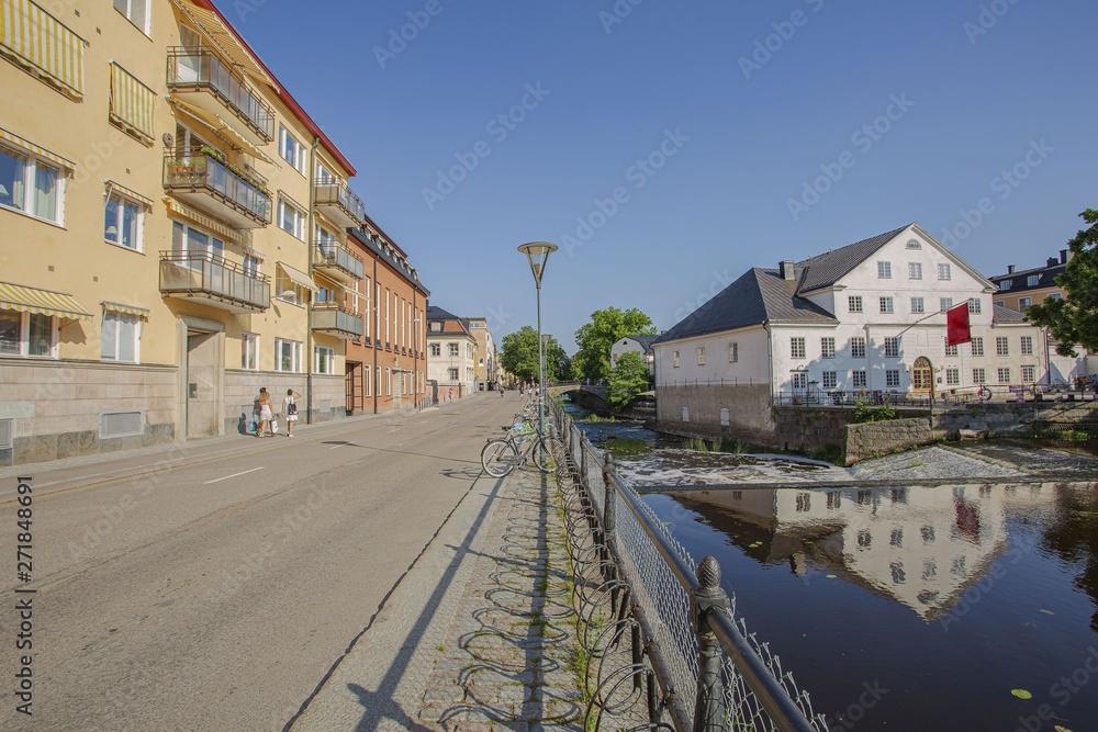 Beautiful view of town street.Yellow and white houses reflecting on water surface. Cloudless blue sky on background. Gorgeous nature landscape backgrounds. Beautiful view of town street.Yellow and white houses reflecting on water surface. Cloudless blue sky on background. Gorgeous nature landscape backgrounds.
