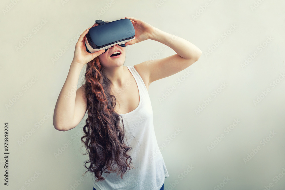 Smile young woman wearing using virtual reality VR glasses helmet headset on white background. Smartphone using with virtual reality goggles. Technology, simulation, hi-tech, videogame concept Smile young woman wearing using virtual reality VR glasses helmet headset on white background. Smartphone using with virtual reality goggles. Technology, simulation, hi-tech, videogame concept