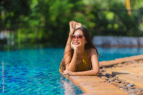 Portrait beautiful young asian woman leisure relax smile and happy around swimming pool in hotel resort
